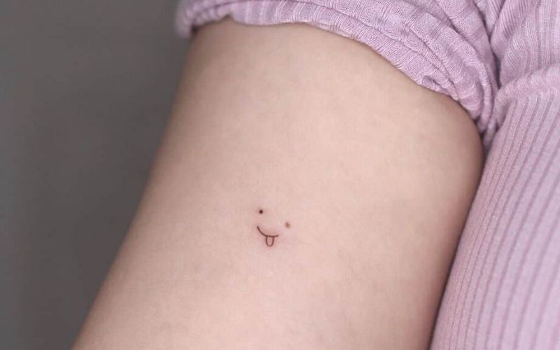 Hình xăm mini mặt cười tinh nghịch với ý nghĩa người con gái năng động và tràn đầy sức sống