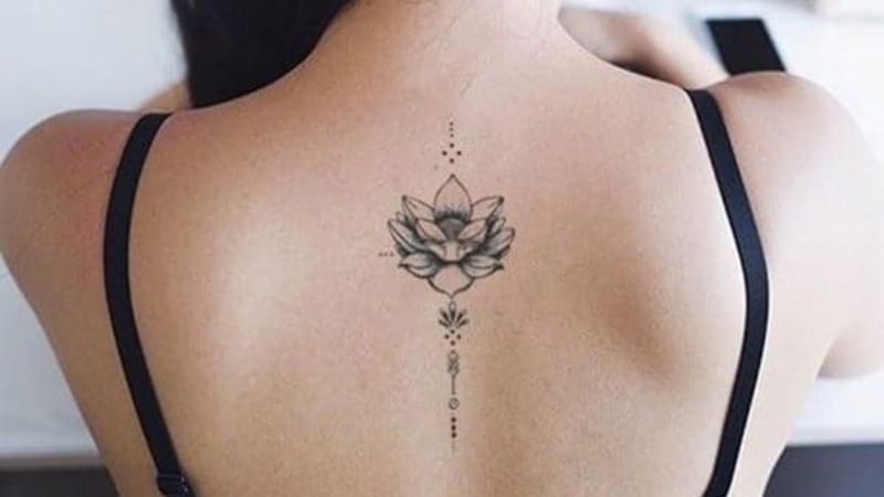 Hình xăm hoa sen mini nằm ở lưng của phụ nữ