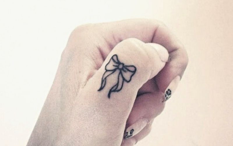 Hình xăm chiếc nơ mini ở ngón tay với ý nghĩa mang lại vẻ đẹp thùy mị, dịu dàng của các bạn nữ