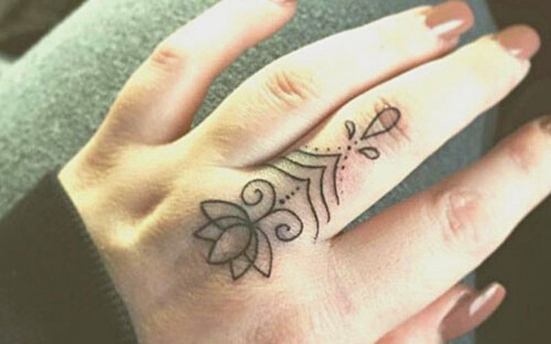Biểu tượng họa tiết hoa sen và giọt nước mini ở tay với ý nghĩa mang lại 1 cuộc sống bình yên