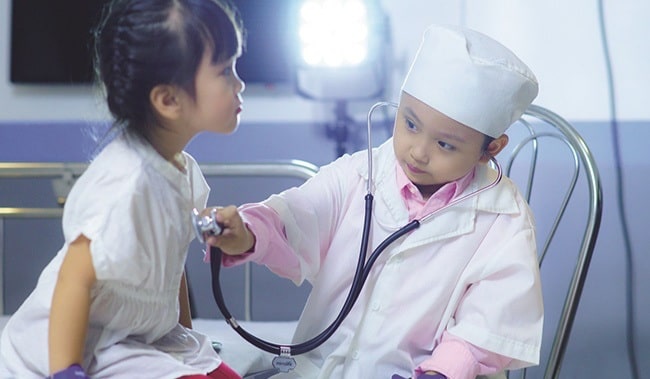 Hình ảnh "Em làm bác sĩ" khám bệnh cho bệnh nhân