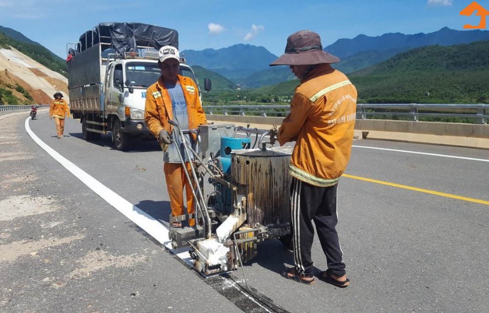 Nhân công đang tiến hành các công đoạn phụ như lắp biển báo, đèn chiếu sáng, kẽ vạch đường....